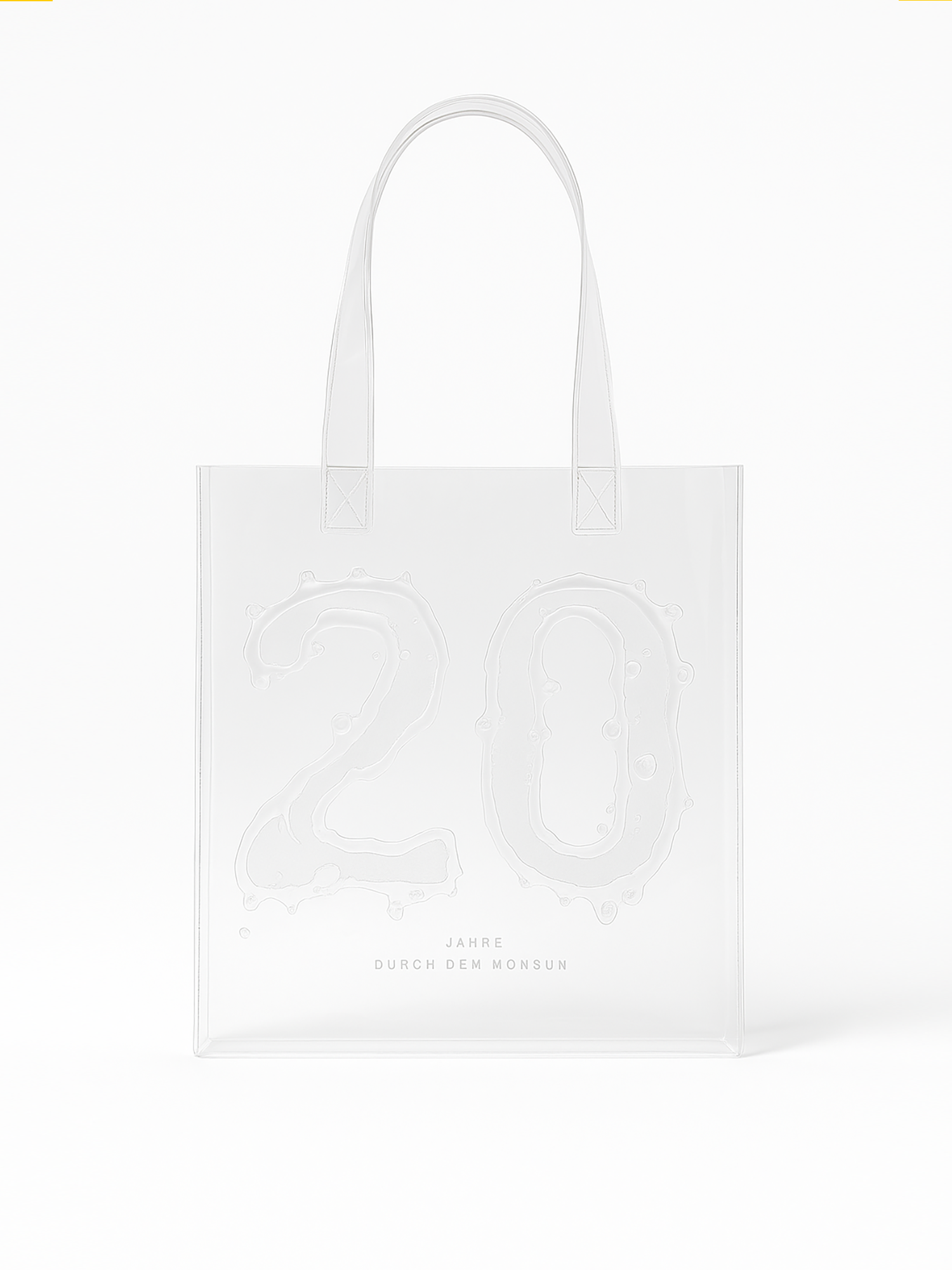 Transparente Tragetasche mit langen Henkeln und geprägtem Design. Auf der Vorderseite ist in großer, wässrig wirkender Schrift die Zahl „20“ eingeprägt. Darunter steht in schlichter, grauer Typografie: „JAHRE DURCH DEN MONSUN“. Die Tasche ist schlicht, modern und erinnert an ein Jubiläum, vermutlich zum 20-jährigen Bestehen des Songs „Durch den Monsun“.