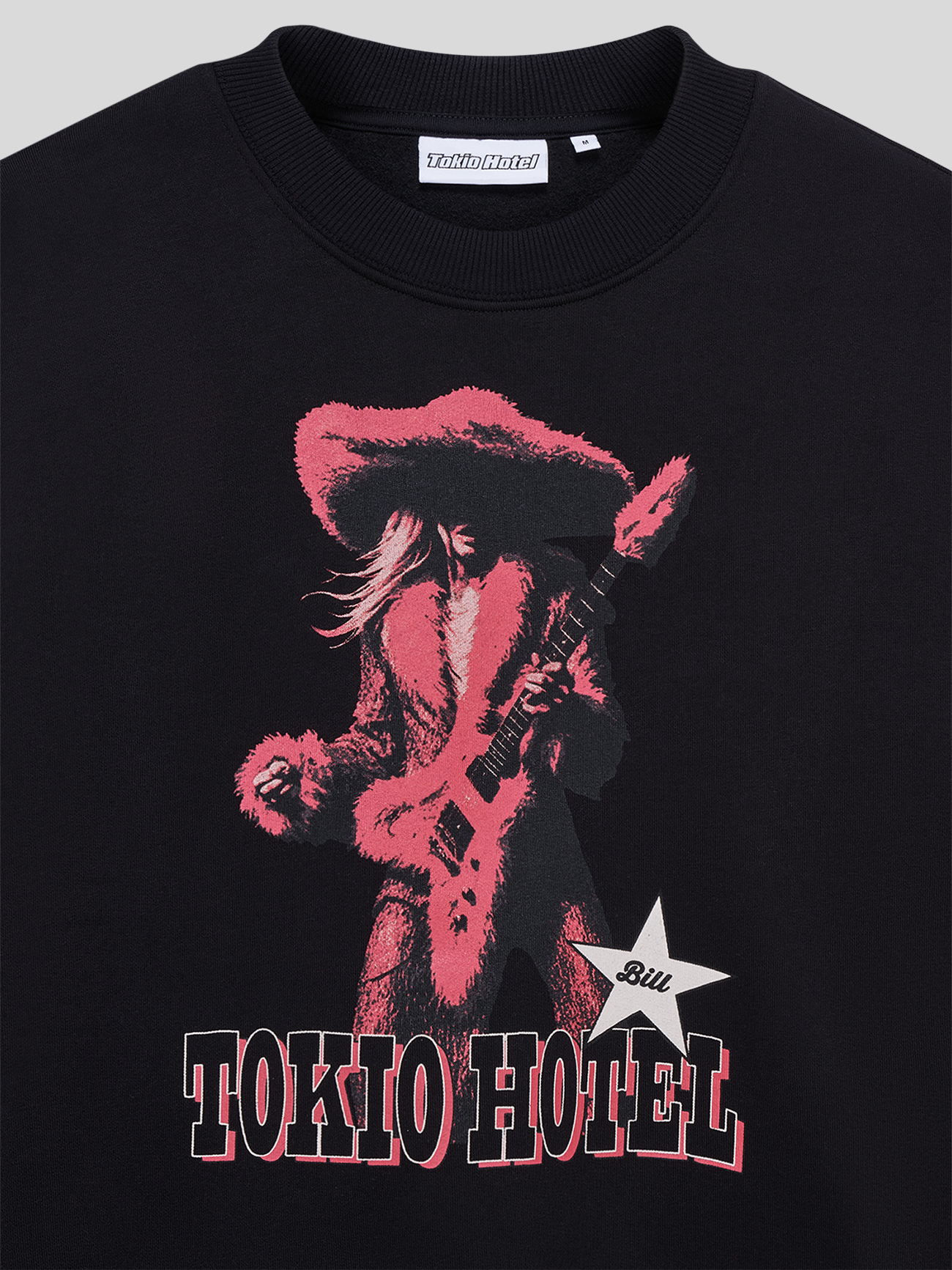 Detailaufnahme des roten Gitarren-Motivs und des „TOKIO HOTEL“-Schriftzugs auf dem schwarzen Sweater.