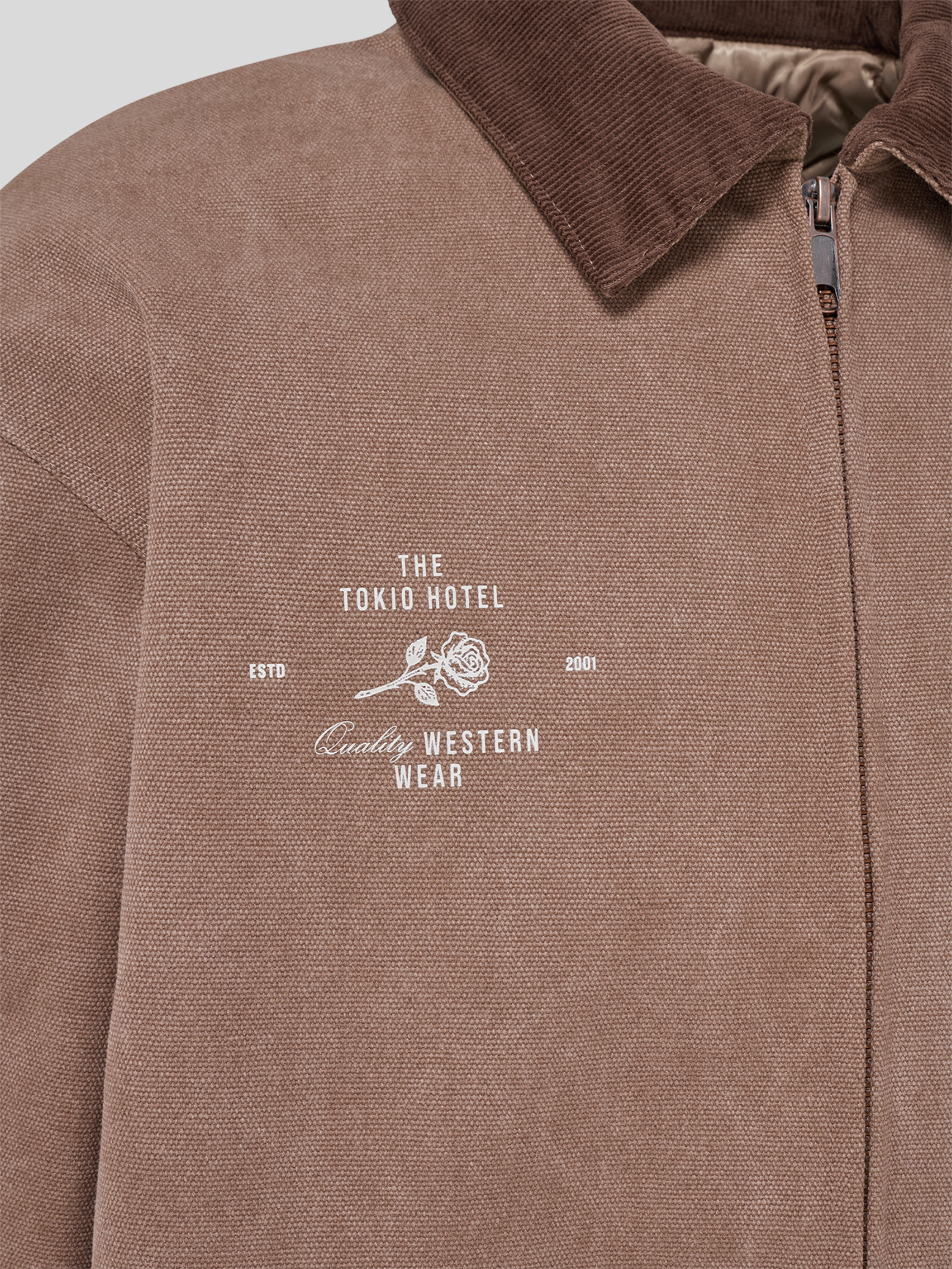 Rückseite der braunen Tokio-Hotel-Jacke mit großem „TOKIO HOTEL“-Schriftzug und Patch im oberen Rückenbereich.