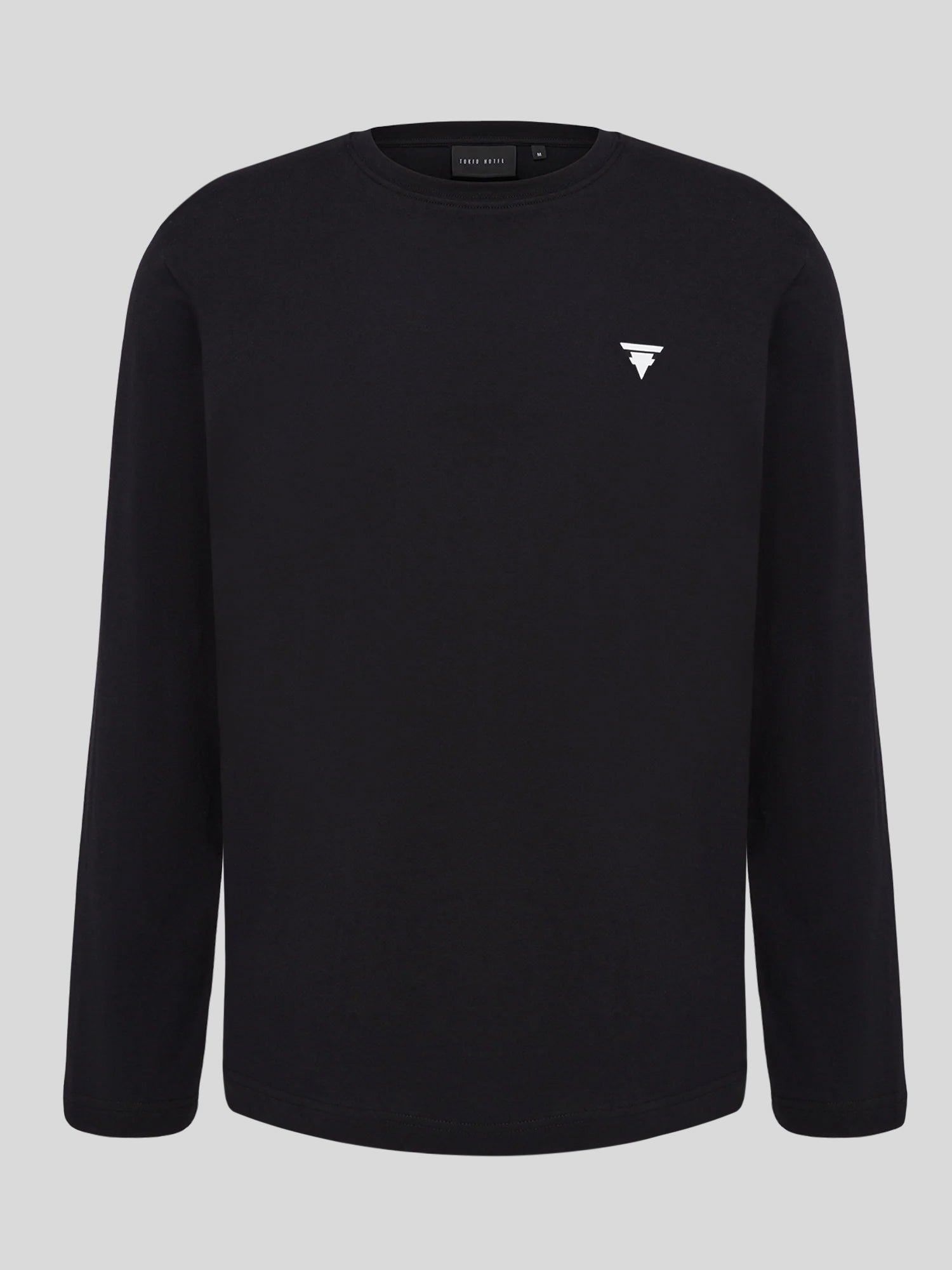 Schlichtes schwarzes Longsleeve mit kleinem, weißem Tokio-Hotel-Logo auf der linken Brustseite. Minimalistisches Design ohne weitere Frontaufdrucke.