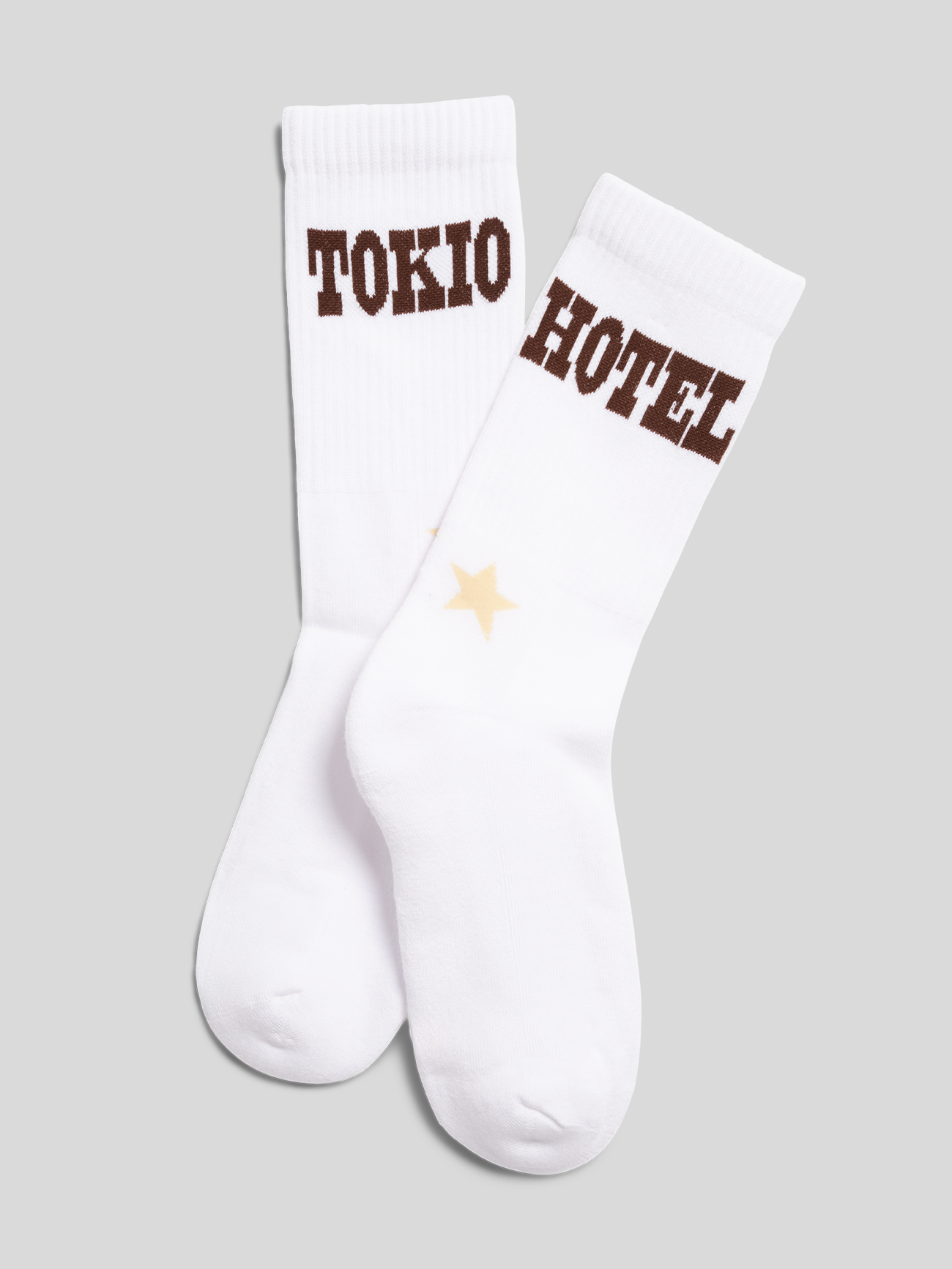 Paar weiße Tokio-Hotel-Socken mit „TOKIO“- und „HOTEL“-Schriftzug sowie Sternmotiv.