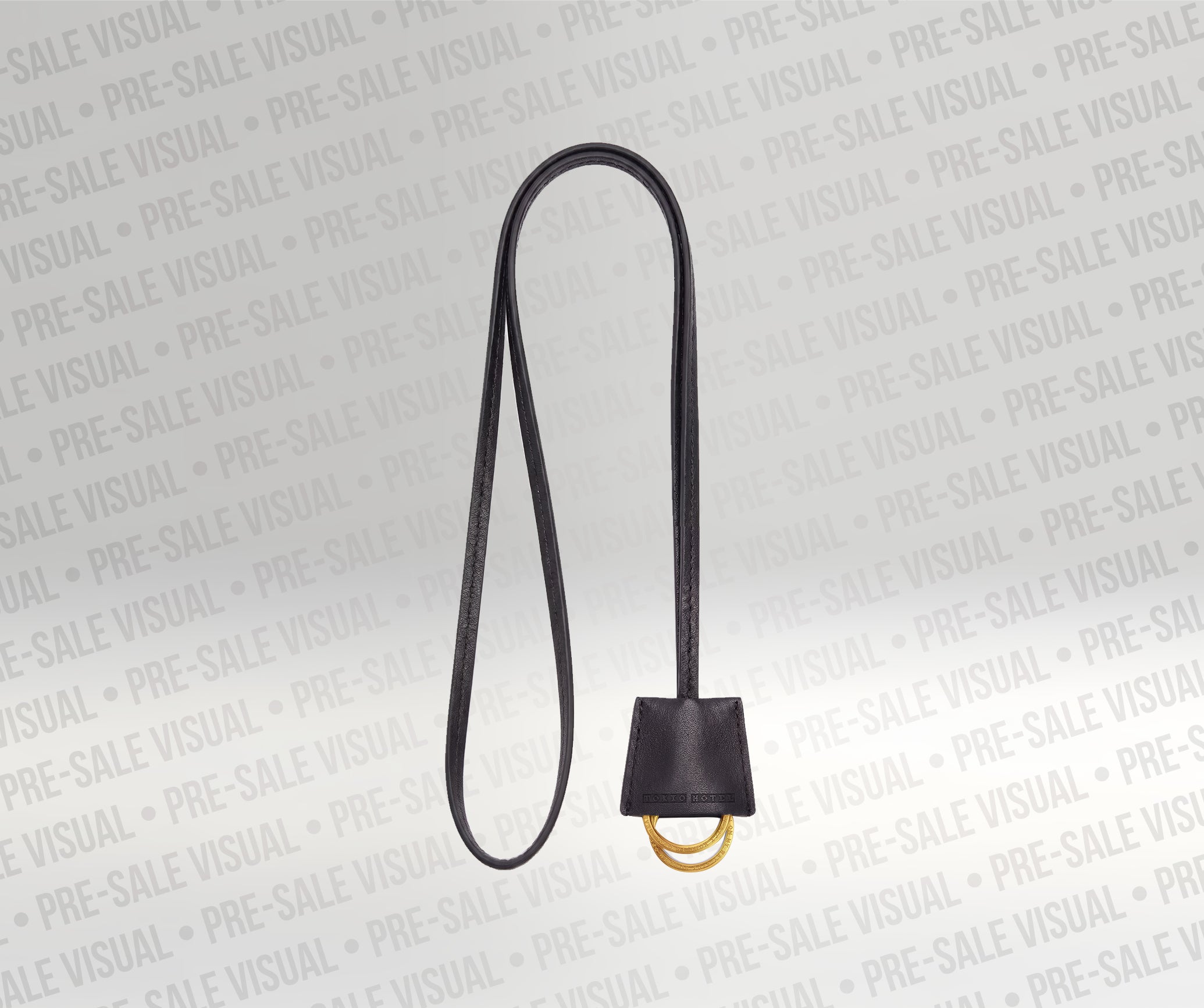 Schwarzer Schlüsselanhänger aus Leder mit goldfarbenem Ring und geprägtem Logo. Minimalistisches Design mit langer Lederschlaufe zum Tragen oder Befestigen von Schlüsseln.