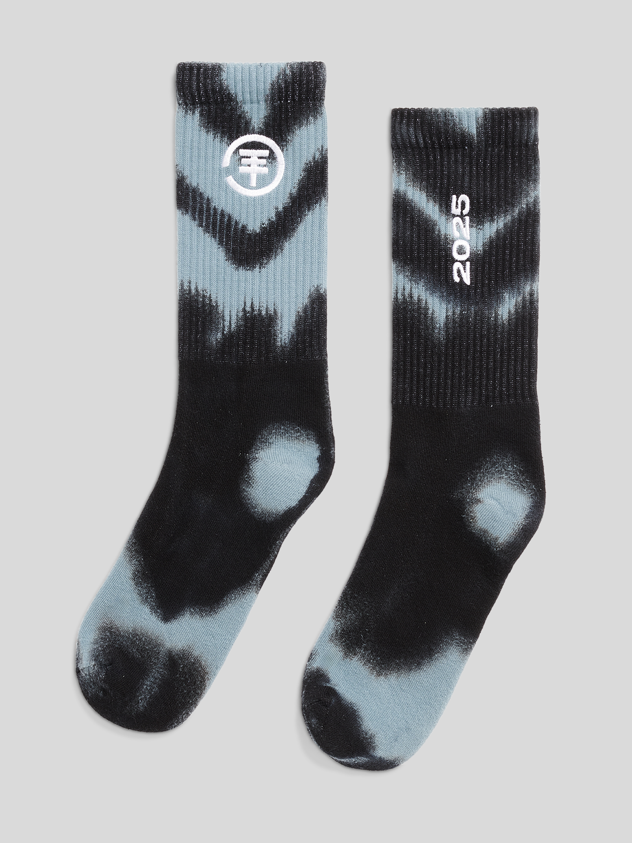 Paar schwarze und hellblaue Batik-Socken. Linke Socke mit weißem Kreislogo am Schaft, rechte Socke mit weißer Zahl ‚2025