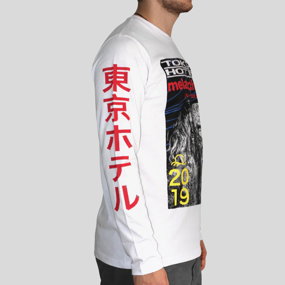 Weißes Langarmshirt mit auffälligem Frontprint im Retrodesign der "Melancholic Paradise Tour 2019" von Tokio Hotel, ergänzt durch japanische Schriftzeichen in Rot auf dem Ärmel. Getragen von einem Mann in Seitenansicht.