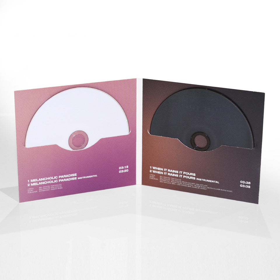 Geöffnete CD-Hülle mit zwei eingeschobenen Discs: links eine weiße CD mit der Aufschrift „Melancholic Paradise“ und rechts eine schwarze CD mit dem Titel „When It Rains It Pours“. Beide CDs sind in Halbhüllen mit Farbverlauf von Rosa zu Dunkelrot eingelegt. Songtitel, Laufzeiten und Credits sind unten jeweils in Weiß abgedruckt.
